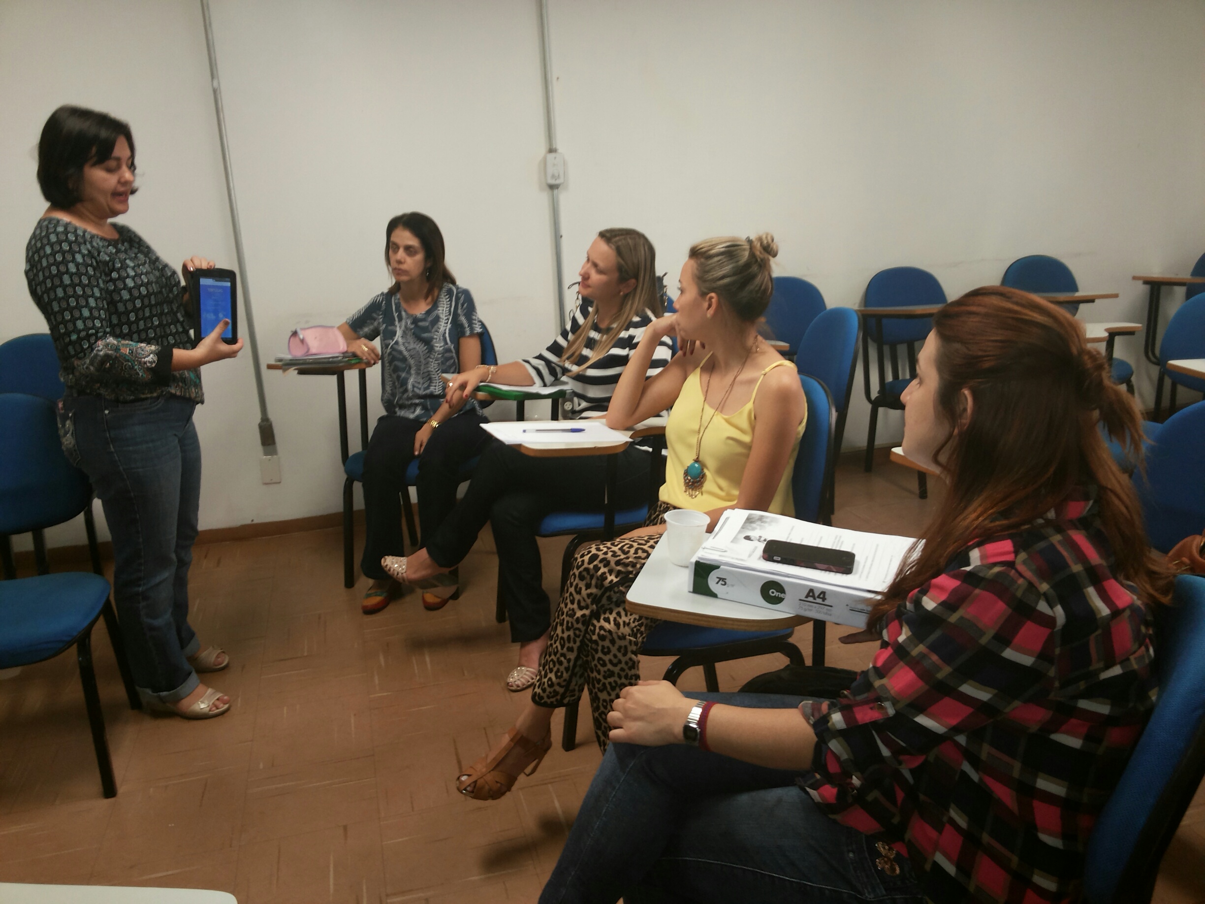 Professora da Educação Digital ensina os coordenadores como utilizar os tablets.